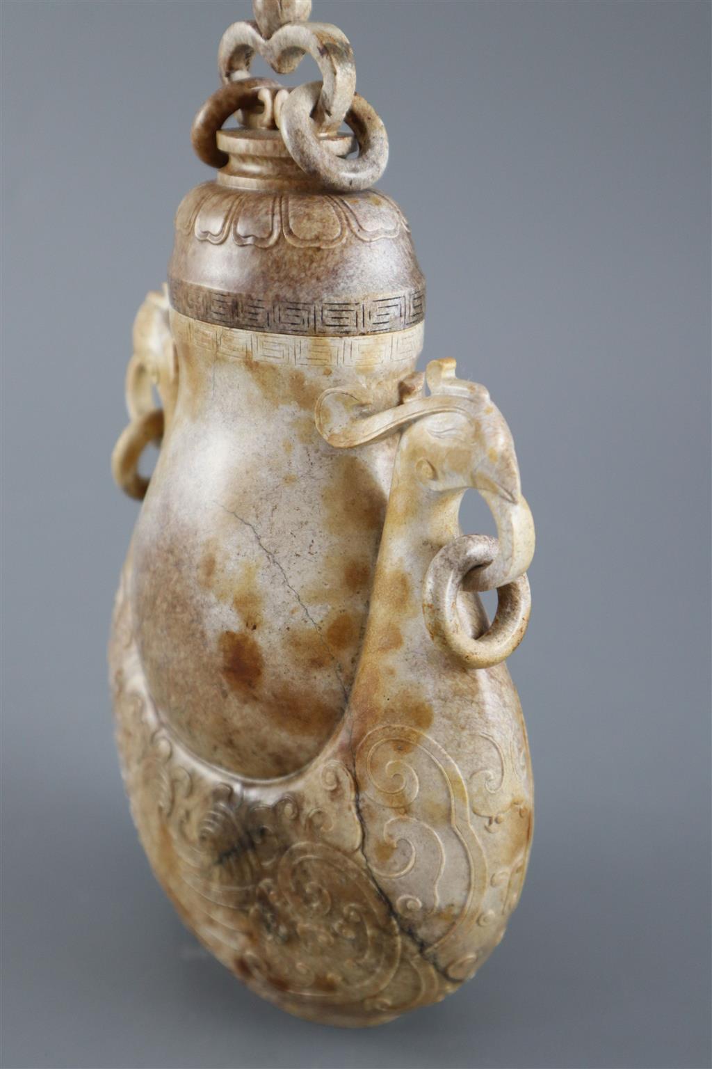 A Chinese archaistic burnt jade phoenix vase and cover, 20cm high